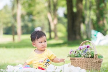 Asya bebek çocuk parkta yeşil çimenlerin üzerinde 