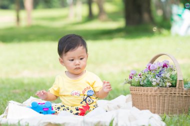 Asya bebek çocuk parkta yeşil çimenlerin üzerinde 