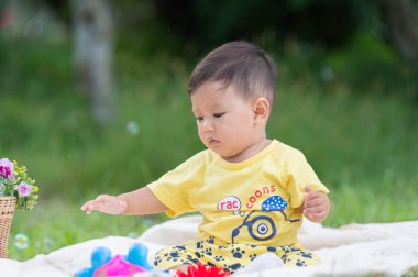 Asya bebek çocuk parkta yeşil çimenlerin üzerinde 