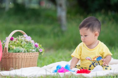 Asya bebek çocuk parkta yeşil çimenlerin üzerinde 