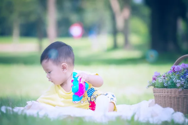 Asya bebek çocuk parkta yeşil çimenlerin üzerinde — Stok fotoğraf