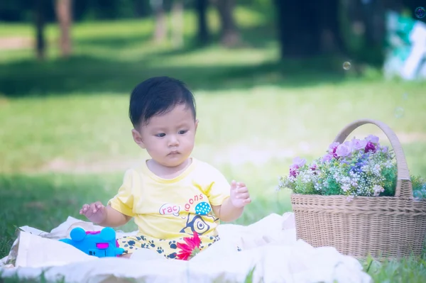 Asya bebek çocuk parkta yeşil çimenlerin üzerinde 