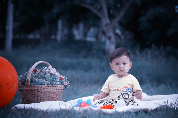 Sabun köpüğü ile yeşil çimenlerin üzerinde oturan erkek Asya bebek 