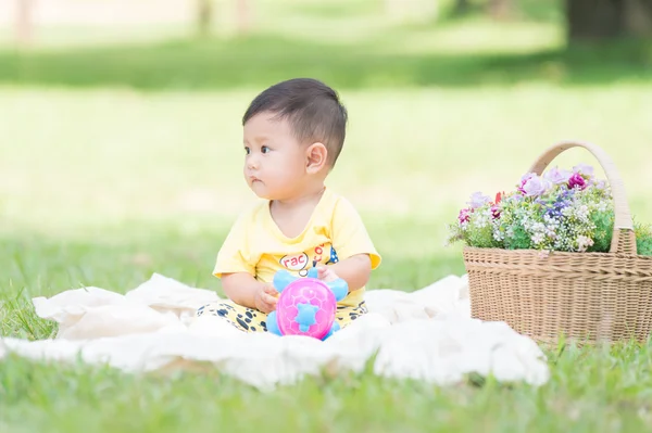 Asya bebek çocuk parkta yeşil çimenlerin üzerinde — Stok fotoğraf