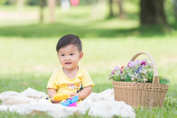 Asie chlapeček na zelené trávě v parku — Stock fotografie