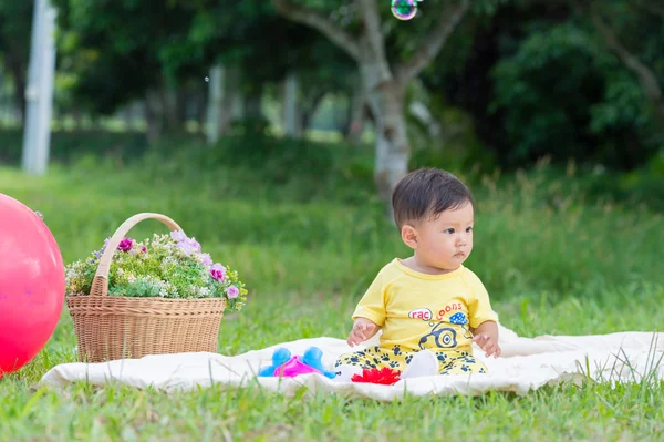 Asia Baby boy sitting on green grass with soap bubbles — Stock Photo, Image