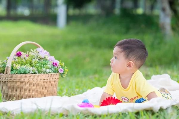 Sabun köpüğü ile yeşil çimenlerin üzerinde oturan erkek Asya bebek 