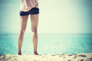 Sahilde duran Asya genç kadın bacakları
