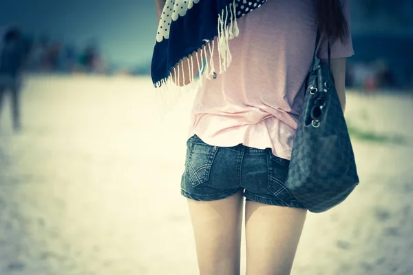 Молодая модная женщина в джинсовых шортах позирует на пляже — стоковое фото