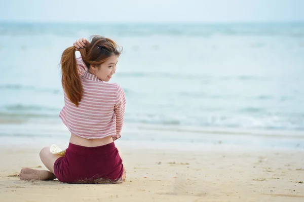 Ασία νεαρή γυναίκα που κάθεται στην παραλία — Φωτογραφία Αρχείου