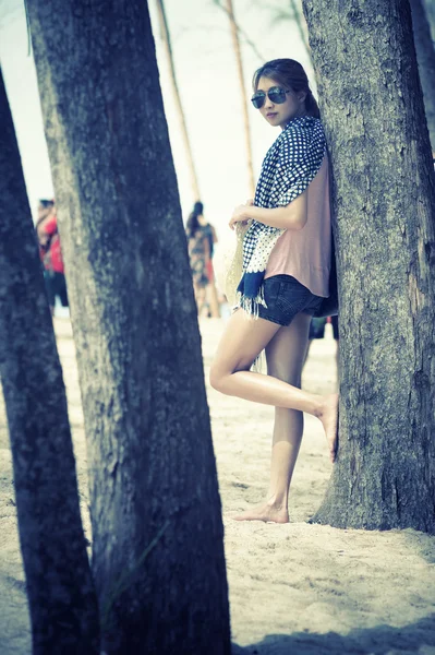 Asia jonge vrouw met pijnbomen op strand — Stockfoto