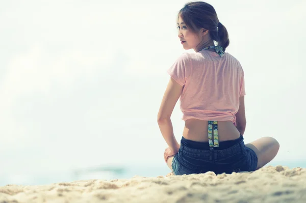 Ásia jovem mulher sentada na praia — Fotografia de Stock