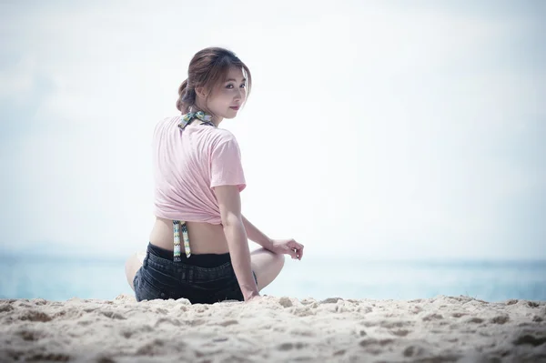 Asie jeune femme assise sur la plage — Photo
