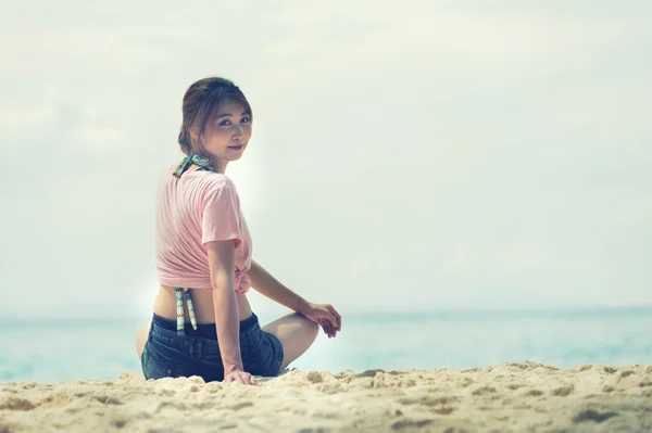 Ásia jovem mulher sentada na praia — Fotografia de Stock