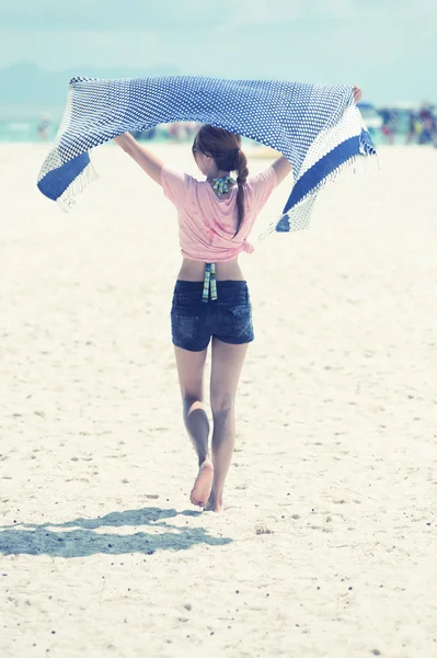 Молодая женщина, идущая по пляжу — стоковое фото