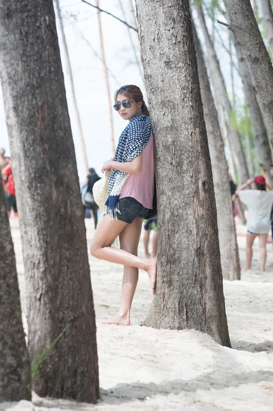 Ασία νεαρή γυναίκα στέκεται με πεύκα στην παραλία — Φωτογραφία Αρχείου