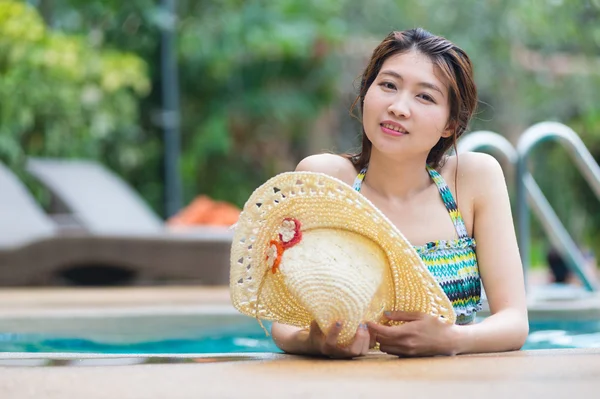アジアの美しい女性とプールでリラックスできる大きな帽子 — ストック写真