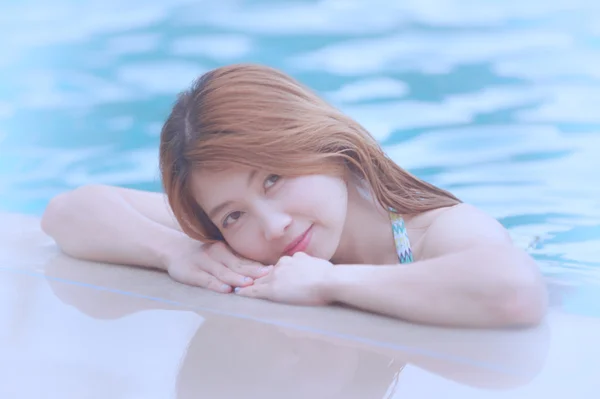 Ásia bela mulher na borda da piscina — Fotografia de Stock