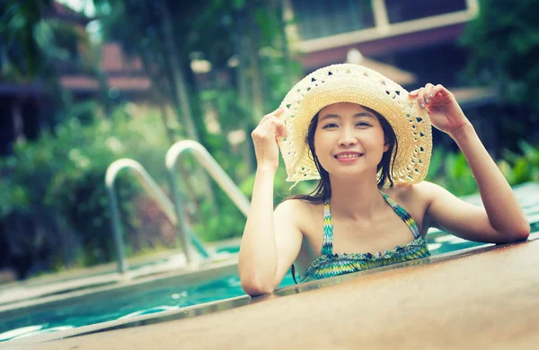 Asie jolie femme en chapeau profiter de la piscine — Photo