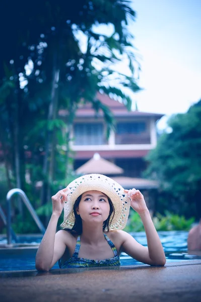 Asie jolie femme en chapeau profiter de la piscine — Photo