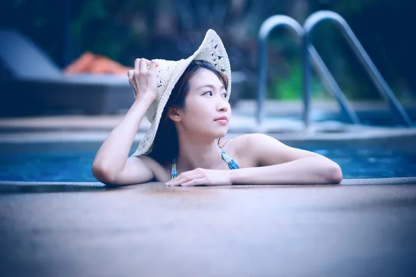 Asie jolie femme en chapeau profiter de la piscine — Photo