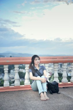 Asya güzel genç kadın terasta oturup 