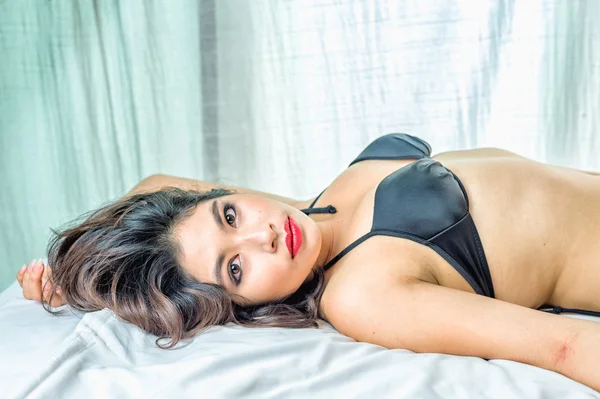 Sexy asiatische Frau schwarz Bikini liegend auf Bett — Stockfoto