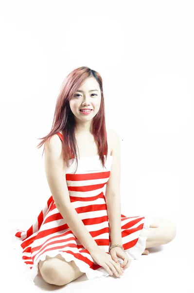 Asie jolie fille en robe blanche rouge assis sur le sol . — Photo