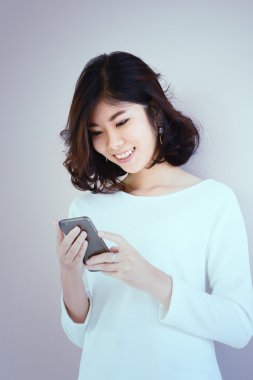 Asya genç güzel Bayan dokunmaktan ve onun akıllı telefon tarama