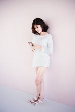 Asya genç güzel Bayan dokunmaktan ve onun akıllı telefon tarama