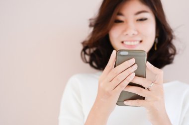 Asya genç güzel Bayan dokunmaktan ve onun akıllı telefon tarama