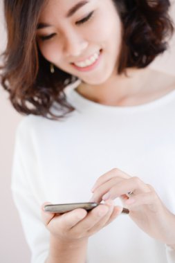 Asya genç güzel kadın cep telefonunuza Sms yazıyor