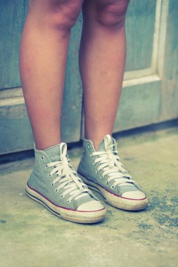 Asya kadınlar ayakkabı ayakta ahşap duvara