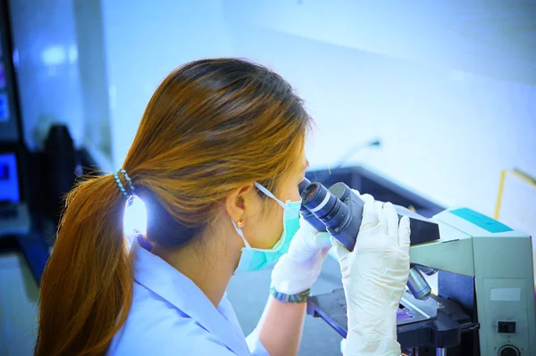 Cientista olhando através do microscópio em laboratório — Fotografia de Stock