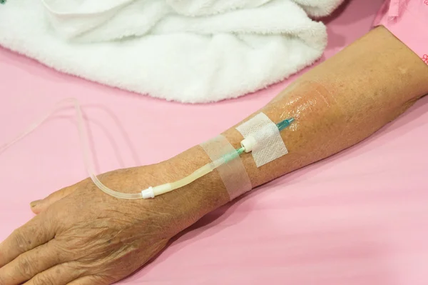 Braço da paciente idosa no hospital com uma IV — Fotografia de Stock