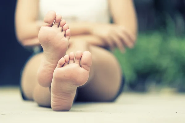 asia woman sitting on  floor. Feet close up. Blurred background.