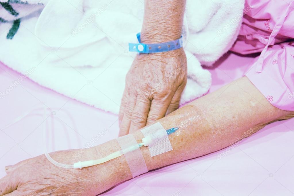 Arm of old woman patient in hospital with an IV