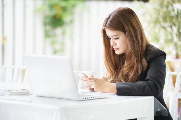 Asia mujer de negocios mensajes de texto en el teléfono inteligente en la cafetería — Foto de Stock