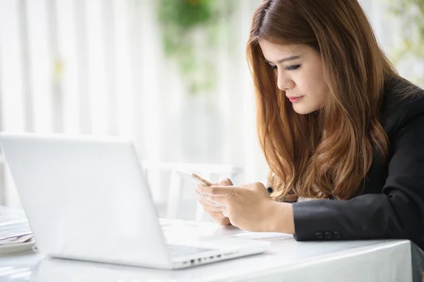 Asia chica de negocios mensajes de texto en el teléfono inteligente en la cafetería — Foto de Stock