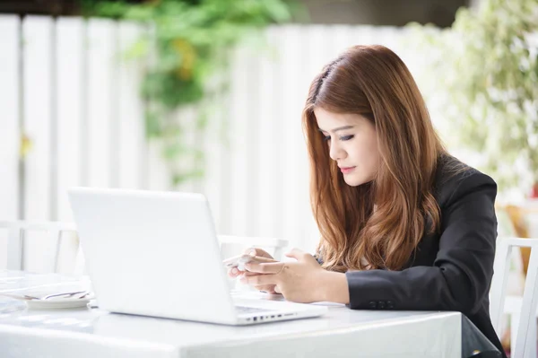 Asia chica de negocios mensajes de texto en el teléfono inteligente en la cafetería — Foto de Stock