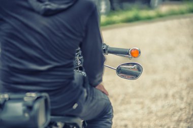 Motorcu adam motorsikletiyle vintage etkisi üzerinde oturuyor