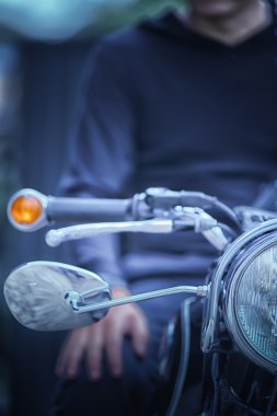 Motorcu adam motorsikletiyle vintage etkisi üzerinde oturuyor