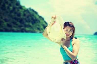 Asya güzel genç kadın şapka plajda bikini ile