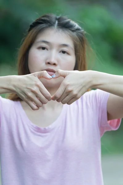 Asie šťastná mladá žena dělat srdce znamení s rukama — Stock fotografie