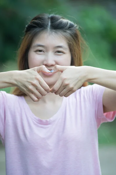 Asia szczęśliwa młoda kobieta co serce znak z rąk — Zdjęcie stockowe