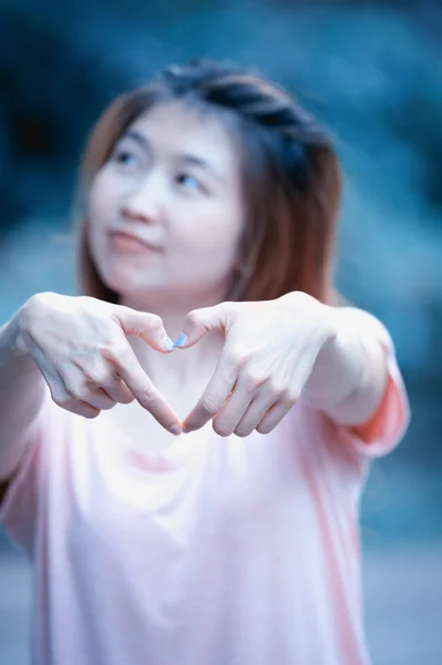 Asia feliz joven mujer haciendo señal de corazón con las manos — Foto de Stock