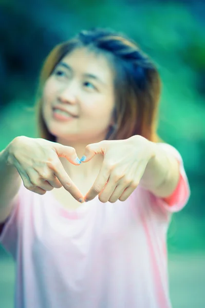 Азия счастливая молодая женщина делает знак сердца с руками — стоковое фото