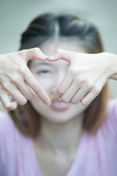 Asia happy young woman making heart sign with hands — Stock Photo, Image