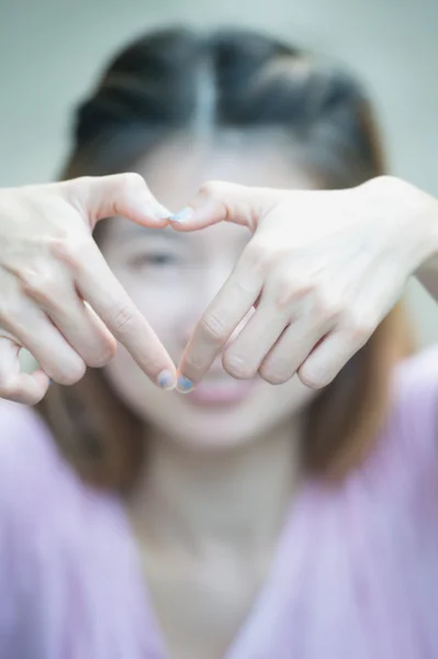 Asia happy young woman making heart sign with hands — Stock Photo, Image