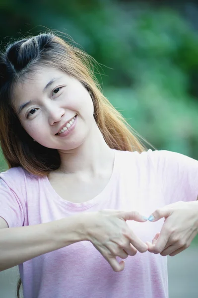 Asia szczęśliwa młoda kobieta co serce znak z rąk — Zdjęcie stockowe